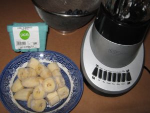 Frozen banana pieces, blueberries and unfancy Black and Decker blender ready to use