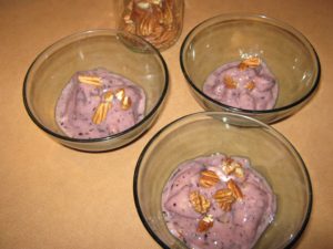 Dishes of banana blueberry ice-cream topped with pecans