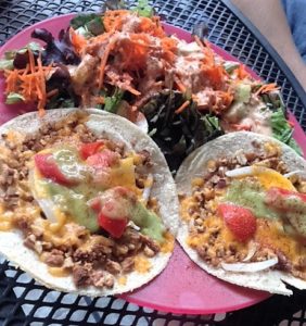 Maggie’s Nut Meat Tacos, made with farmstead cheddar, tomatoes, onions and topped with an avocado cream sauce & served with a delicious green salad