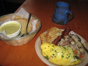 “Veggie omelette with spinach, caramelized onion, grated carrot, avocado & cheddar cheese served with hoe fries and toast plus side order of bacon